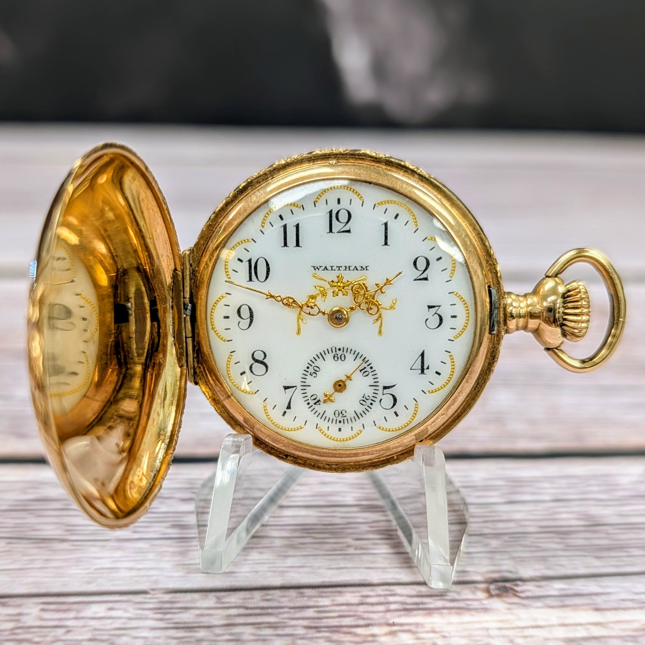 Close-up of Waltham enamel dial with black Arabic numerals and gold details