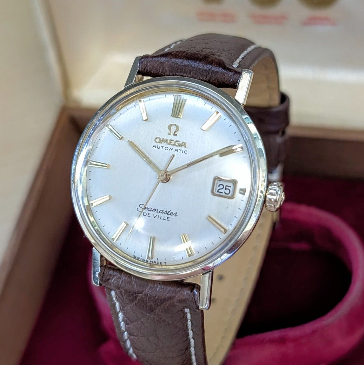 Close-up of silver dial Omega De Ville with date window