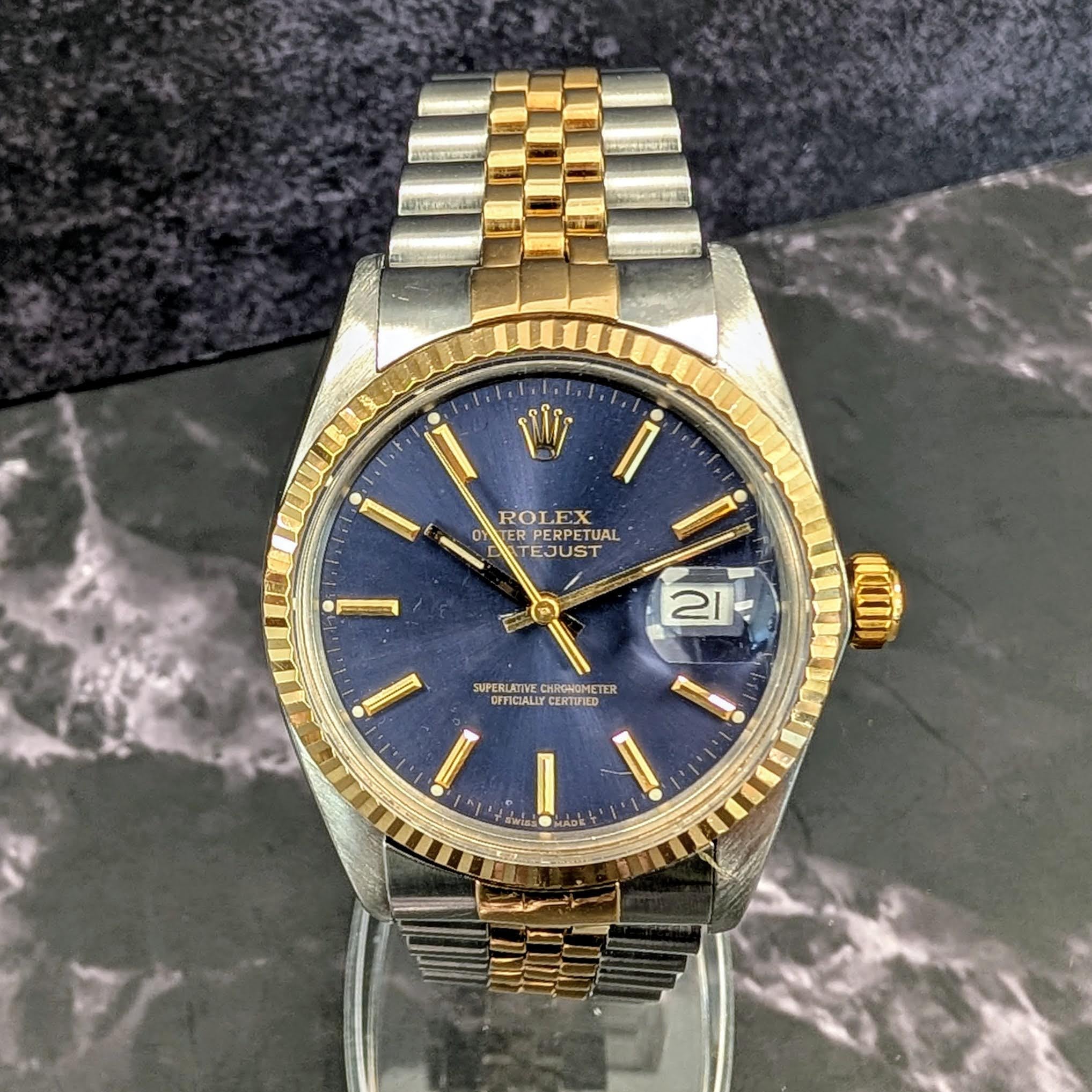 Dial close-up showing sunburst blue finish and gold baton markers